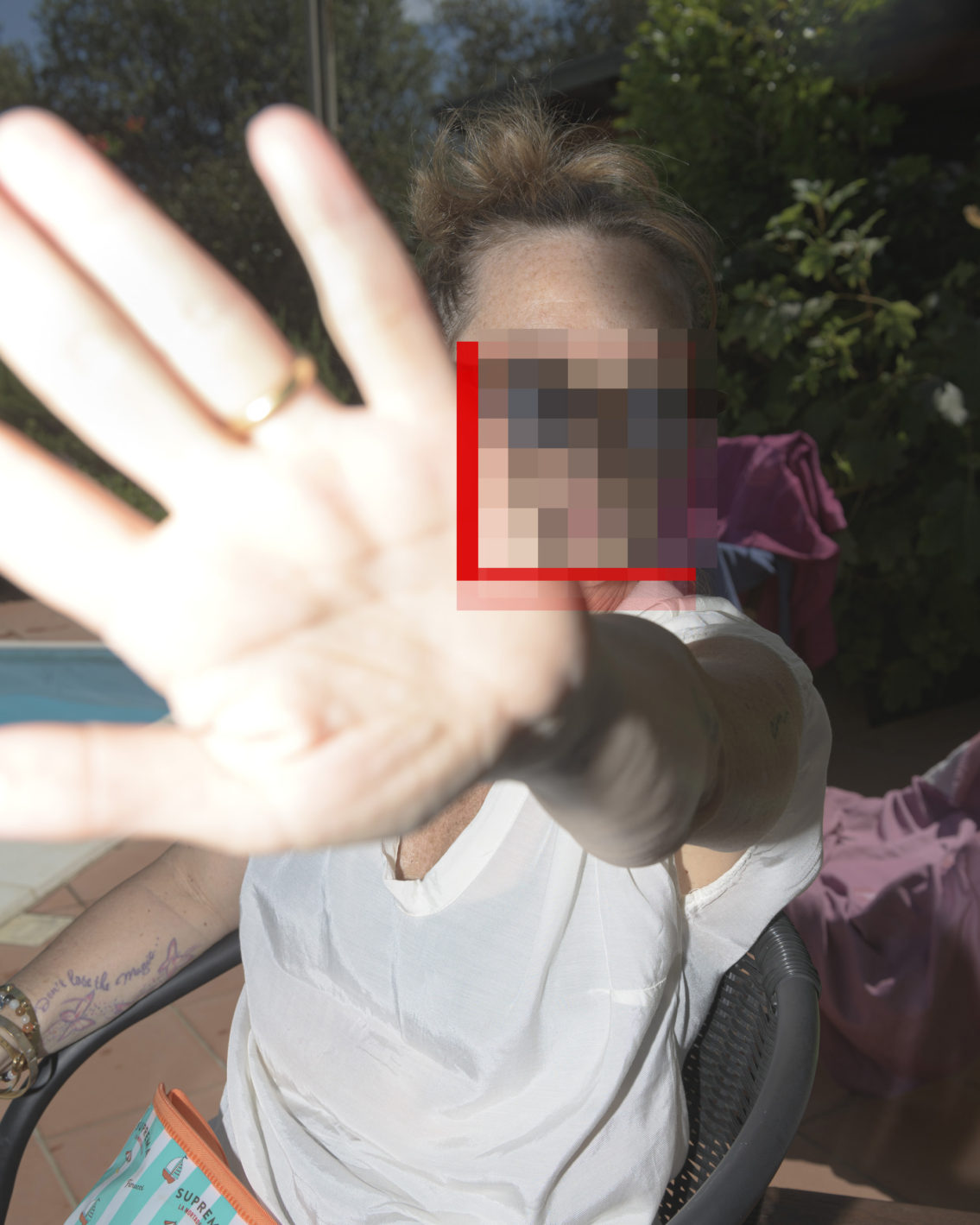 photograph of a woman who covers her face and does not want to be photographed censored