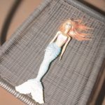 photograph of barbie's little mermaid toy on a plastic chair