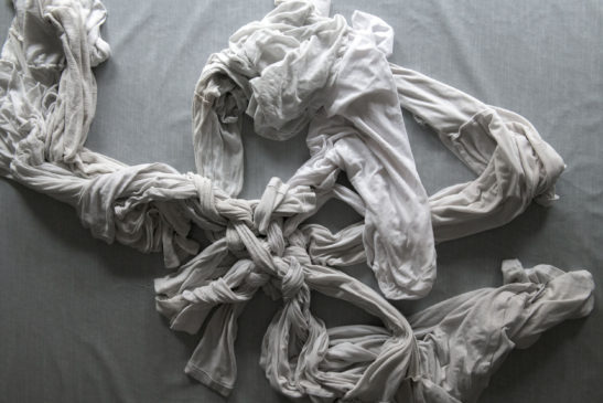 printed photograph of white clothes that came out of the washing machine knotted in a random way